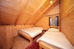 a room with two beds in a wooden cabin at MALËSIA EKO RESORT in Peje