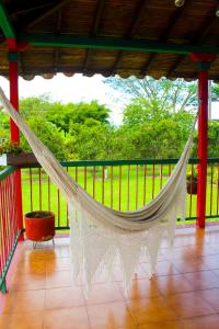a hammock on a porch with a view of a field at Casa Abbá Hotel in La Tebaida