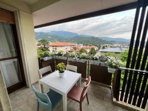una mesa blanca y sillas en un balcón con vistas en View lovely 3bed-2bath condo full furnished., en Vittorio Veneto