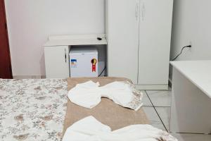 una camera con un letto e asciugamani sul pavimento di Pousada dos Anjos Sao Miguel Arcanjo a São Miguel Arcanjo