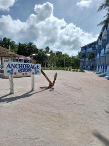 a sign on the beach in front of a building at Anchorage Beach Resort Caye Caulker in Caye Caulker
