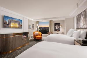 a hotel room with two beds and a television at Bellagio in Las Vegas