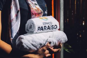 une personne tenant une pile de serviettes pliées dans l'établissement Espaço Paraíso Ortigueira, à Ortigueira