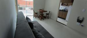 Confort Lencois Preguicas في باريرينهاس: غرفة معيشة مع أريكة رمادية ومطبخ