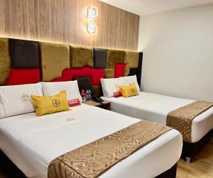 Habitación de hotel con 2 camas con almohadas amarillas y rojas en Montreal Magdalena Del Mar Hotel, en Lima