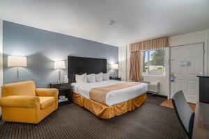 a hotel room with a bed and a chair at Travelodge by Wyndham Traverse City MI in Traverse City