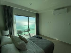 una camera da letto con un letto con vista sull'oceano di Departamento en renta en The One Mazatlan a Mazatlán Altre 22 foto