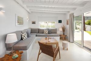 a living room with a couch and a table at Casa Sabbia 10m from the beach in Pelekas