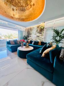 a living room with blue couches and a table at Tropical Villa in Adeje