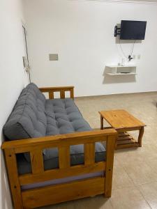 un letto con panca e tavolo in una stanza di APART LUCIA a Esperanza
