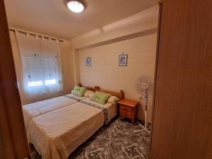 - une chambre avec un lit, une fenêtre et un ventilateur dans l'établissement Piso a 3 minutos de la playa del zapillo (Almeria), à Almería