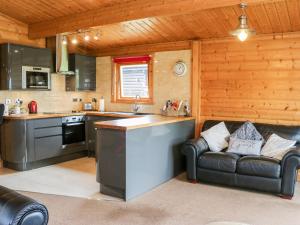eine Küche und ein Wohnzimmer mit einem Sofa und einem Herd in der Unterkunft Heathcliff Lodge in Northallerton