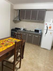 a kitchen with a table and a refrigerator at APART LUCIA in Esperanza