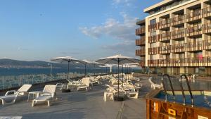 a group of chairs and umbrellas next to a building at PARADISO 402 Private Apartment Nessebar in Nesebar