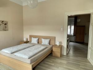 una camera da letto con un grande letto con lenzuola bianche di Stadtapartment WOHNEN48.AT a Klagenfurt