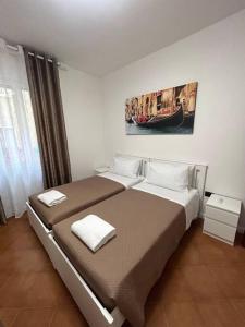 a bedroom with two beds and a painting on the wall at Casa di sara in Mestre +35 photos