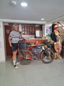 un uomo in piedi accanto a una bicicletta in un negozio di Casa CarpeDM a Quito