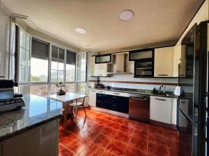 una cucina con armadietti bianchi e pavimenti in legno di La casuca de Logan a Castro-Urdiales
