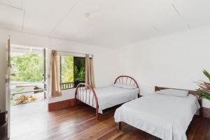 um quarto com 2 camas e uma janela em Mar Caribe PV em Puerto Viejo
