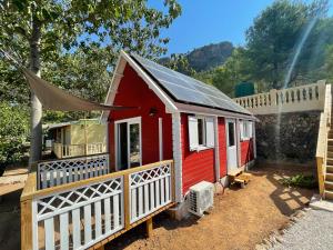 a red tiny house with a white fence at Camping la escalada in Gandía