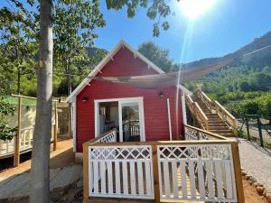 una pequeña casa roja con una valla blanca en Camping la escalada, en Gandía