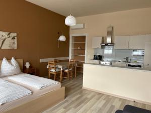 a bedroom with a bed and a kitchen with a table at Stadtapartment WOHNEN48.AT in Klagenfurt