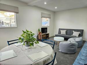 a living room with a table and a couch at 4 Bedrooms, VERY Central Townhouse! in Wellington