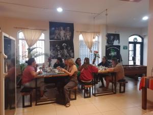 a group of people sitting at tables in a restaurant at Casa CarpeDM in Quito