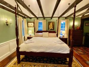 una camera con letto a baldacchino e lenzuola bianche di Silsbee's by Daniels House a Salem