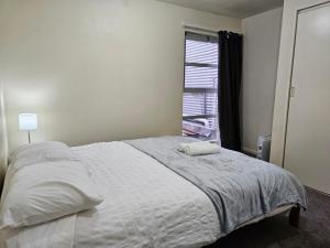 una camera da letto con un grande letto bianco e una finestra di 4 Bedrooms, VERY Central Townhouse! a Wellington
