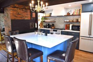 a kitchen with a large blue island with chairs at Silsbee's by Daniels House in Salem