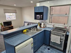 uma cozinha com um balcão azul e um lavatório em 4 Bedrooms, VERY Central Townhouse! em Wellington