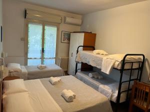 een kamer met 3 stapelbedden en een raam bij Hotel Morri - il BIBLIHOTEL in Riccione