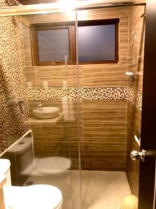 uma casa de banho com um chuveiro, um WC e um lavatório. em Condominio La Victoria, departamento em Cuenca