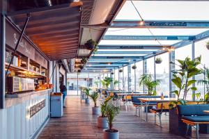 a restaurant with tables and chairs and plants at Sundeck botel - party boat in Bratislava