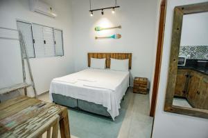 a bedroom with a white bed in a room at Flats de Sumatra in Boicucanga