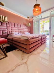 a large bed in a room with pink walls at Tropical Villa in Adeje