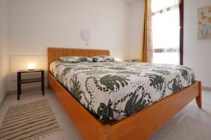 Schlafzimmer mit einem Bett mit einer schwarzen und weißen Bettdecke in der Unterkunft Apartamento El Gato in Costa Del Silencio