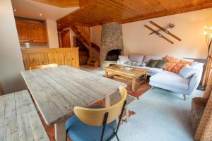 Una sala de estar con una mesa de madera y un sofá. en Grand Duc 8, en Méribel 15 fotos más