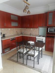 a kitchen with red cabinets and a table and chairs at Four Reasons Apts Ampelokipi in Thessaloniki