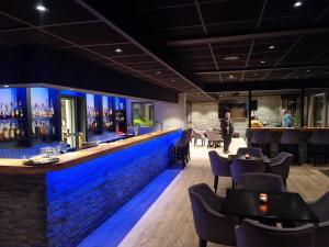 bar z niebieskim oświetleniem w restauracji w obiekcie Bremanger Fjord Hotell w mieście Svelgen
