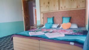 een groot bed met drie kussens en ondergoed erop bij Summer and winter homestay Turtuk Youl in Turtok