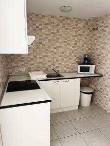 cocina con armarios blancos y microondas en Home2Book Casita Frontera Wonderful Terrace en Frontera