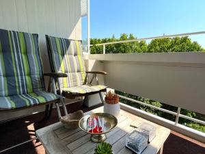 un patio con 2 sillas y una mesa en el balcón en Panoramic App A03-5, en Sierksdorf