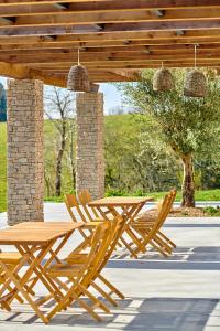 a wooden table and chairs under a wooden pergola at Domaine Etxezahar in Bardos
