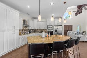 a kitchen with a large island with black chairs at Marco Island's Delight in Marco Island