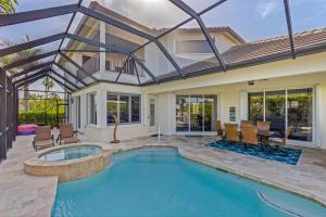 a swimming pool with chairs and a house at Marco Island's Delight in Marco Island