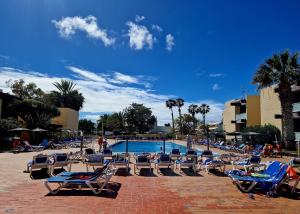 a group of lounge chairs and a swimming pool at Apartamento El Gato in Costa Del Silencio
