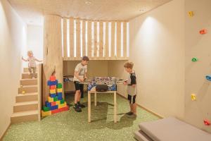 twee kinderen spelen met een tafel in een speelkamer bij Apartments Silva Mountain in San Giovanni in Val Aurina