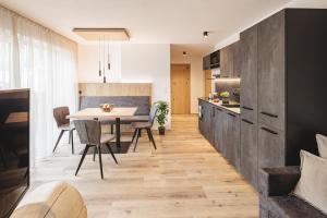 een keuken en eetkamer met een tafel en stoelen bij Apartments Silva Mountain in San Giovanni in Val Aurina